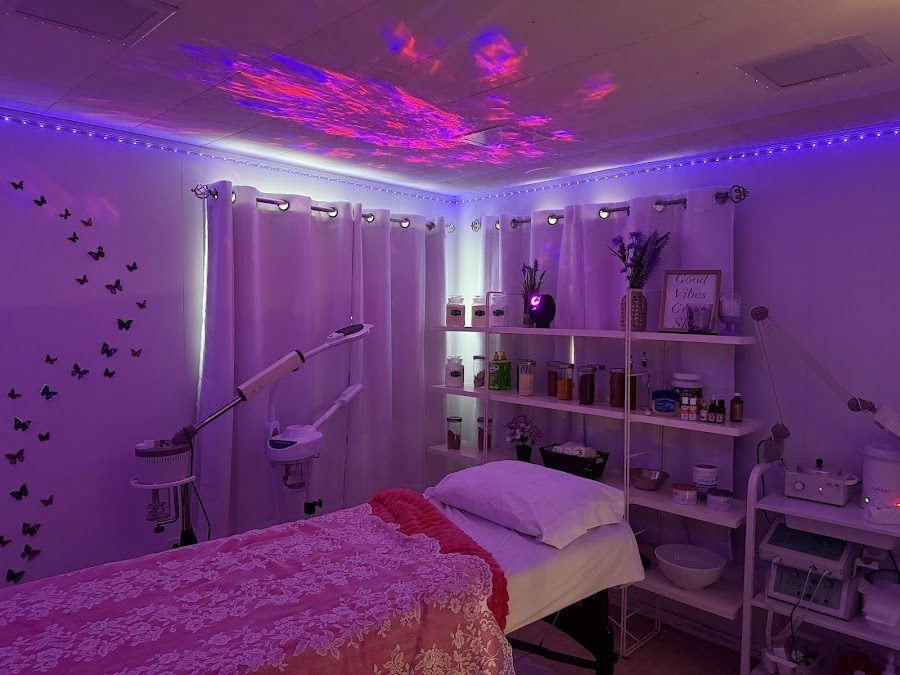 A calm, purple-lit massage room at Pure Era